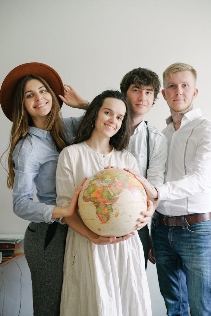 People Standing Close Together Touching a Desk Globe